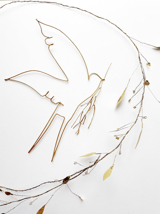 Hirondelle en fil de fer avec branche, décoration artisanale de De Beaux Souvenirs, ornée d'une petite aile en fil métallique.