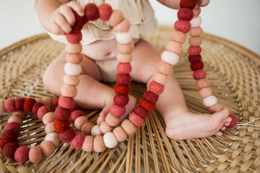 Guirlande de boules en feutre Cozy Rosy Garland de Joy Felts, décoration douce avec boules roses et naturelles en feutre.